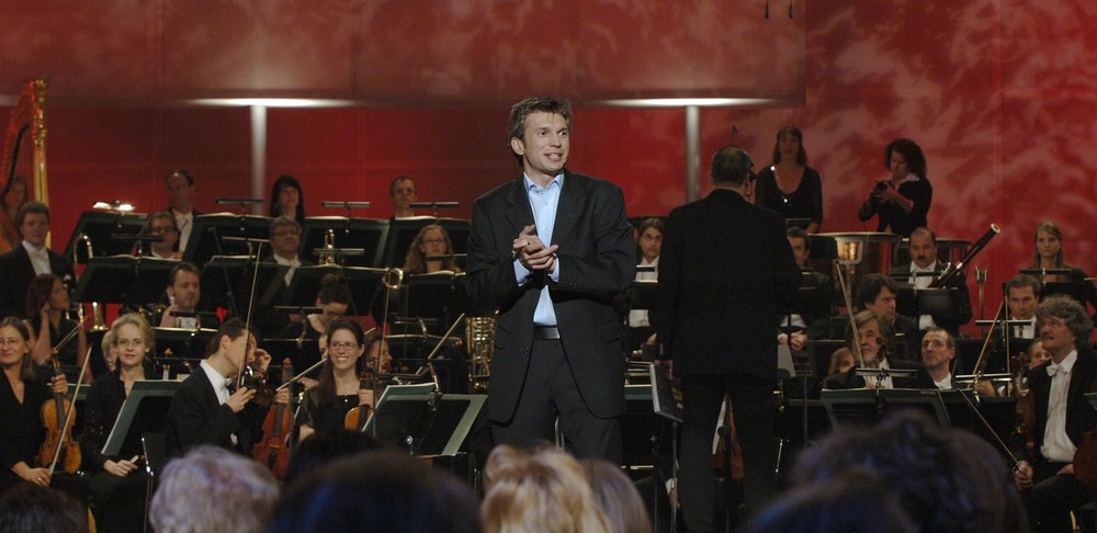 Moritz Küffner auf großer Bühne vor Orchester und Publikum